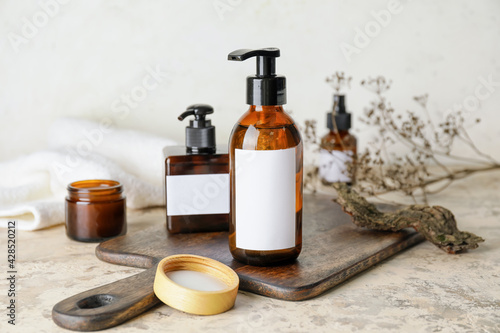 Bottles with natural shampoo on light background photo