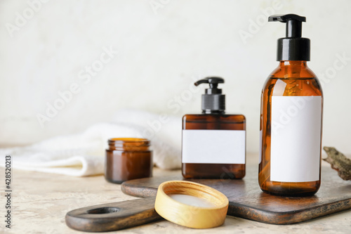 Bottles with natural shampoo on light background