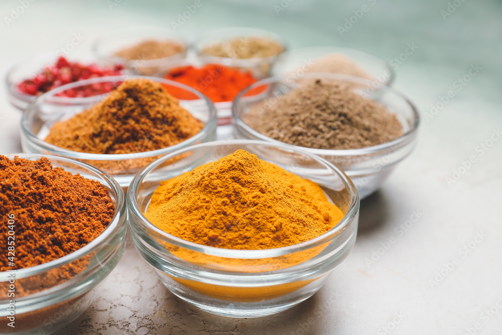Bowls with different spices on light background, closeup Bowls with different spices on light background, closeup