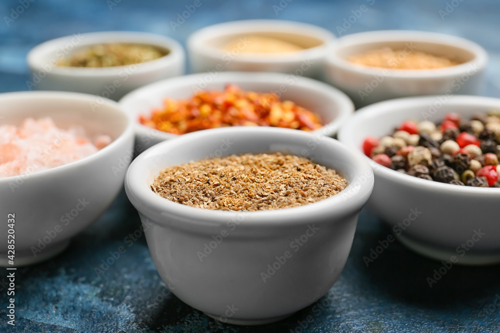 Bowls with different spices on color background, closeup Bowls with different spices on color background, closeup