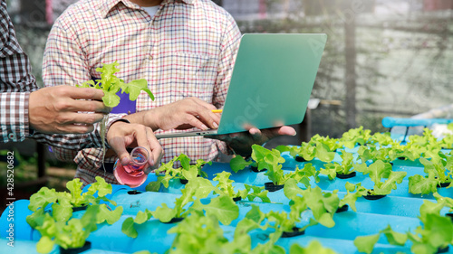 Tableau sur toile Farmers pour microbial fertilizer into hydroponic vegetable fields in the nursery greenhouse