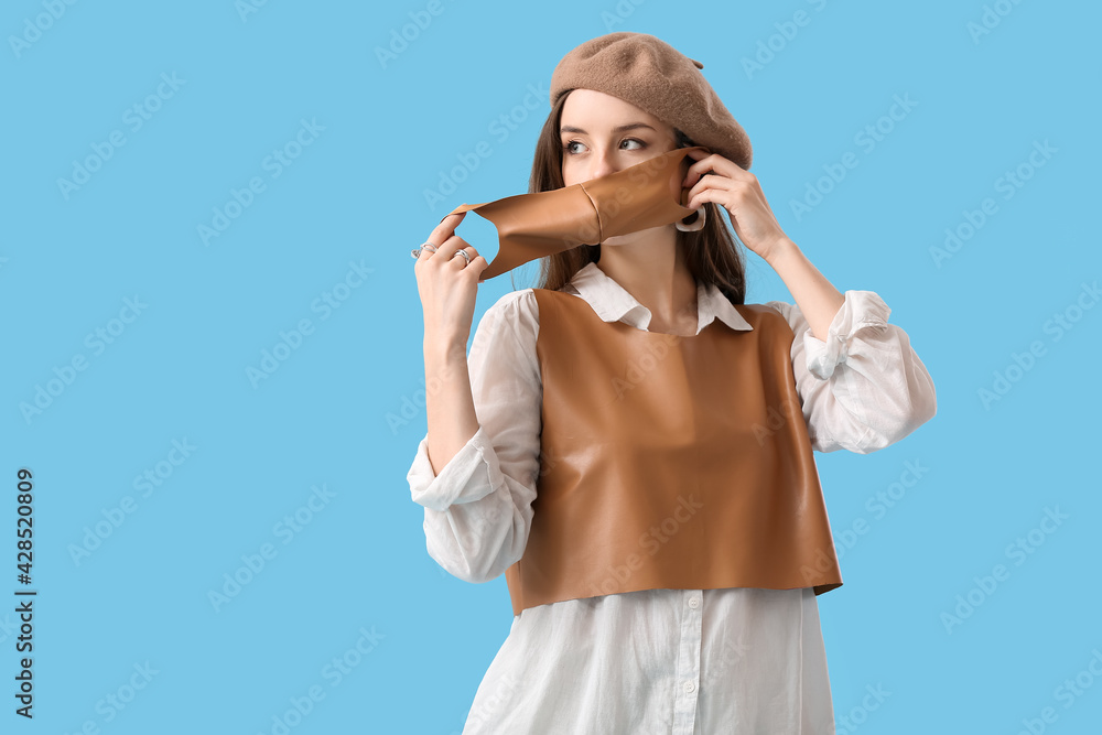 Fashionable young woman wearing mask on color background Fashionable young woman wearing mask on color background