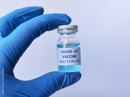 Vaccine concept of fight against corona virus. Selective focus hand holding vaccine bottle.