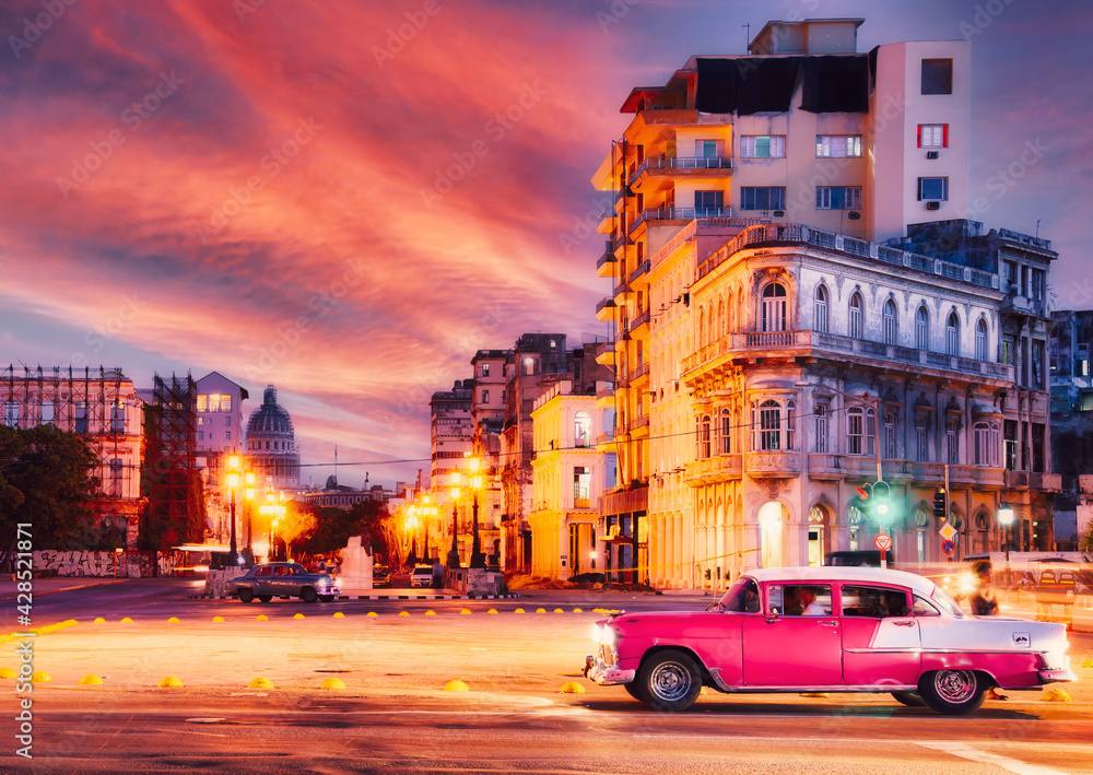 Urban scene with classic car at sunset in Old Havana - Long exposure.Unrecognizable people