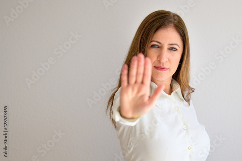 Determined focused woman giving a halt gesture with her hand