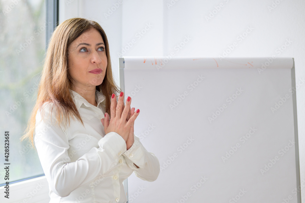 Businesswoman standing in front of a flip board deep in thought Businesswoman standing in front of a flip board deep in thought