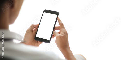 Man hands holding smart phone with blank copy space screen for your text message or information content, female reading text message on cell telephone during in urban setting.