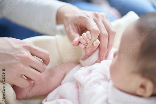 パパの指を握るアジア人の赤ちゃん
