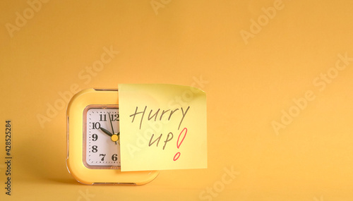 Alarm clock with hurry up message stick on it.