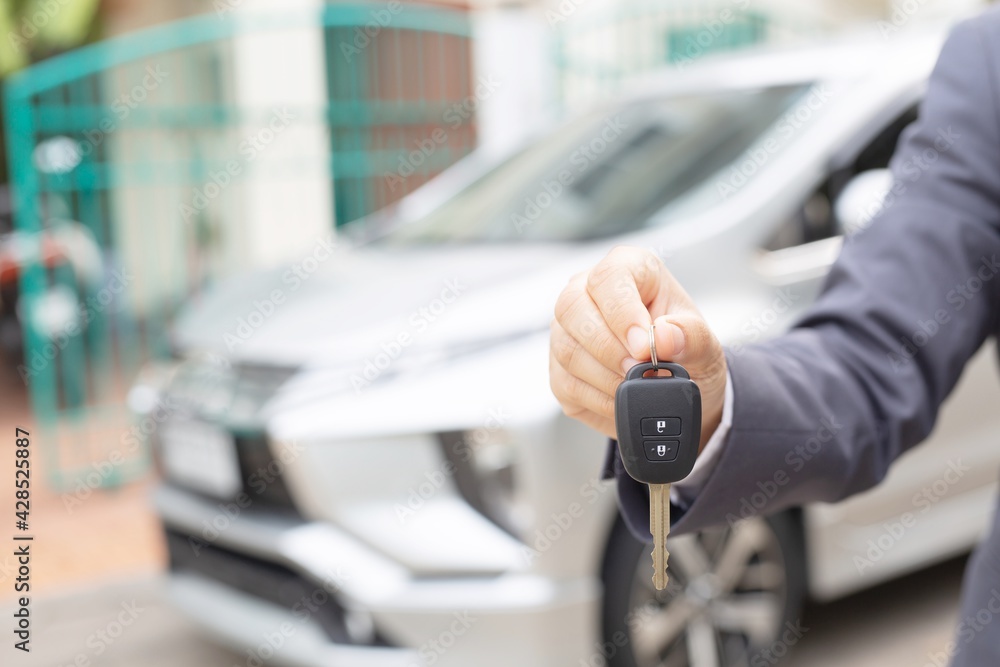 custom made wallpaper toronto digitalA woman holds a car key in front of a car in a showroom.