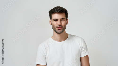 Young bearded man wearing t-shirt winking © Svitlana