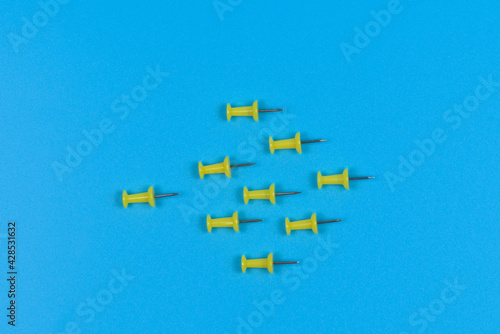 Nine push pins pointing one way on a blue background