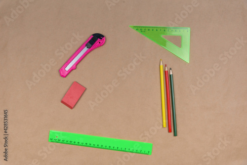 Office supplies lie on craft paper. View from above