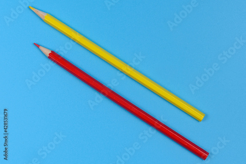 Red and yellow pencil on blue background