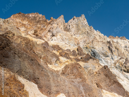 Climbing Mutnovsky volcano. View of the peaked rocks of the Mutnovsky volcano against the background of the blue sky. Kamchatka Peninsula, Russia.