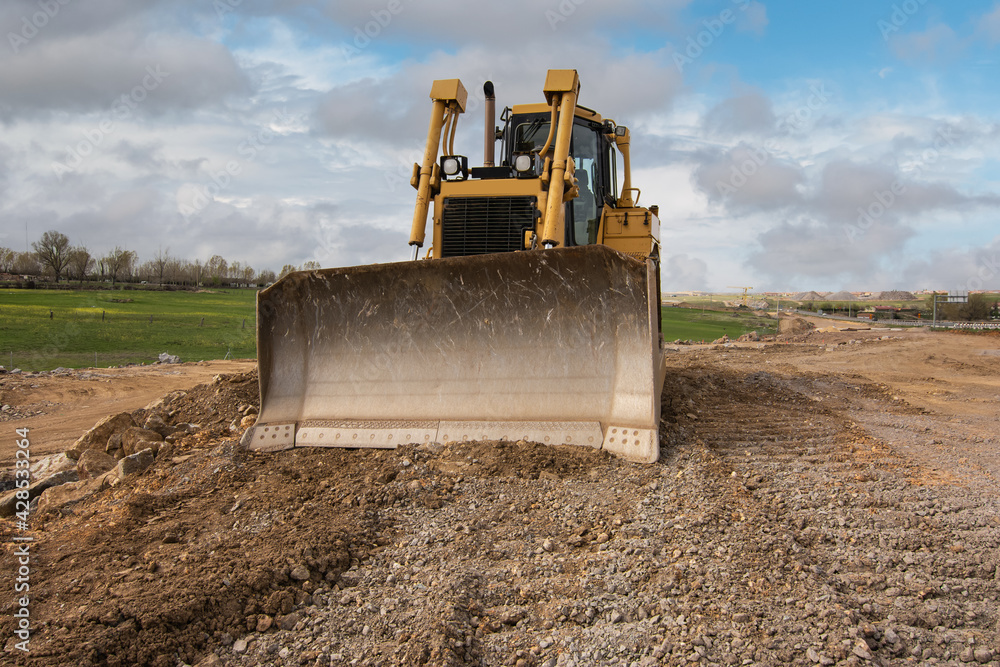 Excavator building a road in a site construction Excavator building a road in a site construction