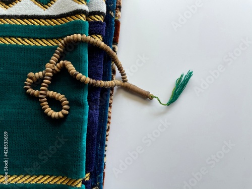 prayer beads and prayer mats on white background