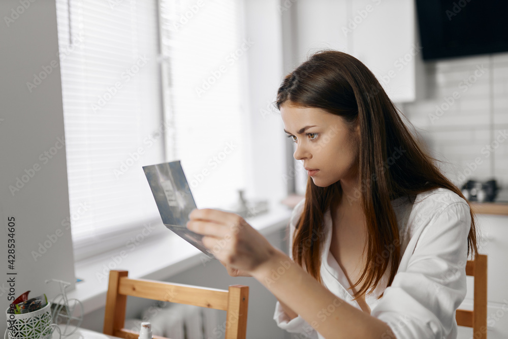 woman doing face makeup and mirror in hand window in the background woman doing face makeup and mirror in hand window in the background