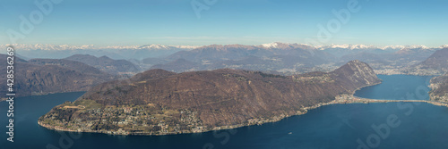 Panoramic view on lake lugano, morcote, monte san salvatore and lugano city seen from monte san giorgio. Typical swiss spring landscape with lake