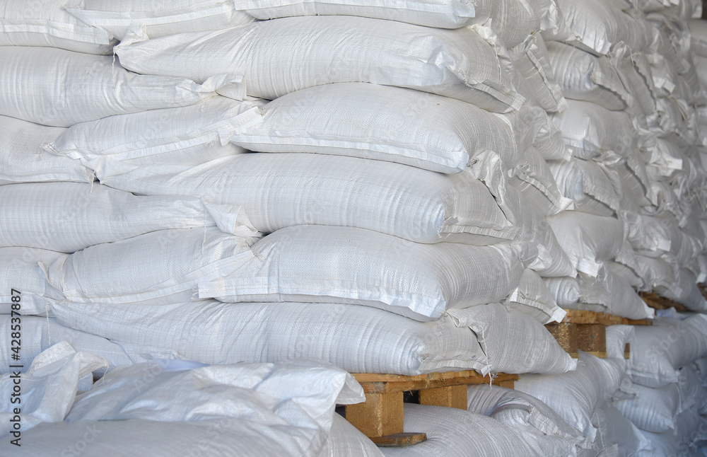 Sacks of rice are placed in straight rows on wooden pallets, a farm warehouse. Sacks of rice are placed in straight rows on wooden pallets, a farm warehouse.