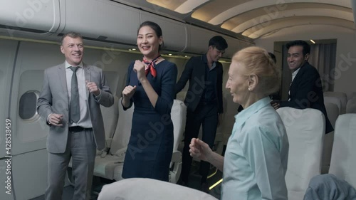 Airline workers and passengers are dancing happily on the plane.