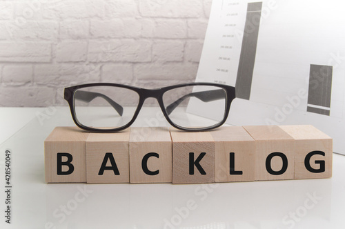 the word lag, written on cubes on a light office background with glasses and papers, business concept