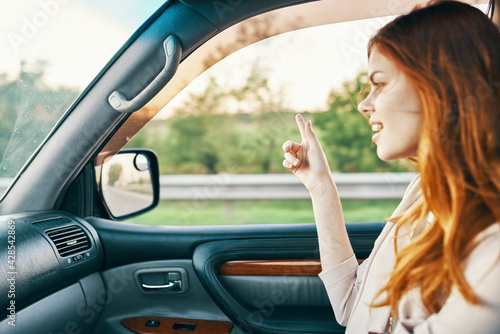 happy woman in sweater driving on the front seat of a car clean interior design model © SHOTPRIME STUDIO