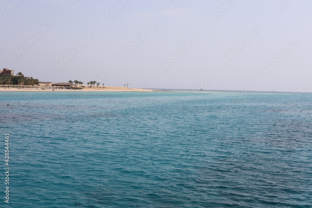 Clear waves on the beach. Beauty of beach in the morning. Blue water ripples. Wonderful swim in clean turquoise sea water. Scenic backdrop of beautiful transparent water of the Red Sea with sun shine