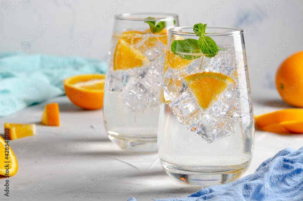 Hard seltzer cocktail with orange, mint and ice.