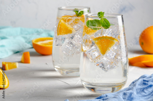 Hard seltzer cocktail with orange, mint and ice.
