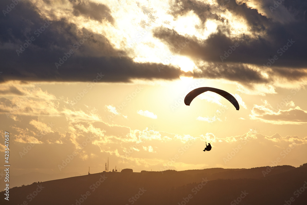 Paraglider silhouette at sunset