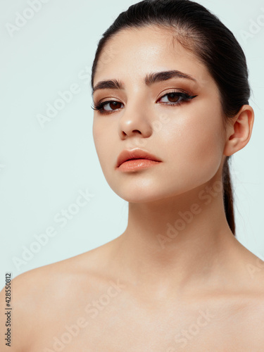 beautiful woman with bare shoulders and makeup on face cosmetology dermatology