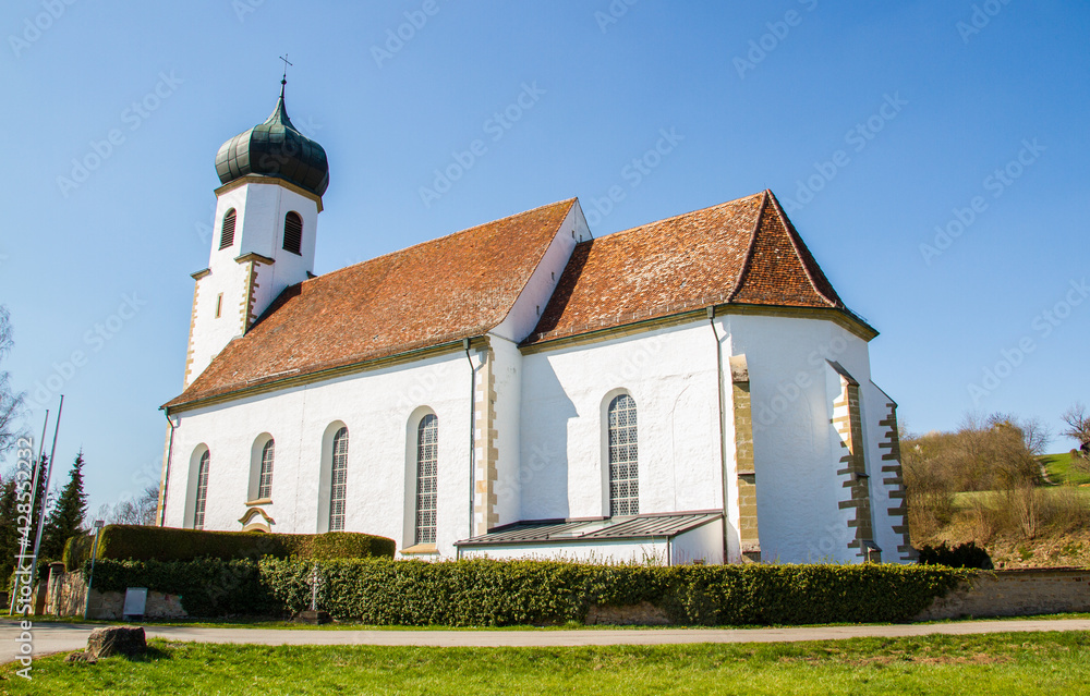 White church St. Stephanus at Poltringen, Ammerbuch near Tuebingen, Baden-Wuerttemberg, Germany, with blue sky in spring