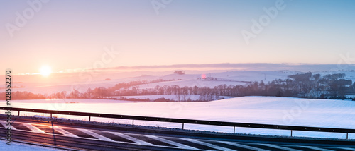 Fototapeta Naklejka Na Ścianę i Meble -  Winter landscape, sunset over the hills near the national road.
