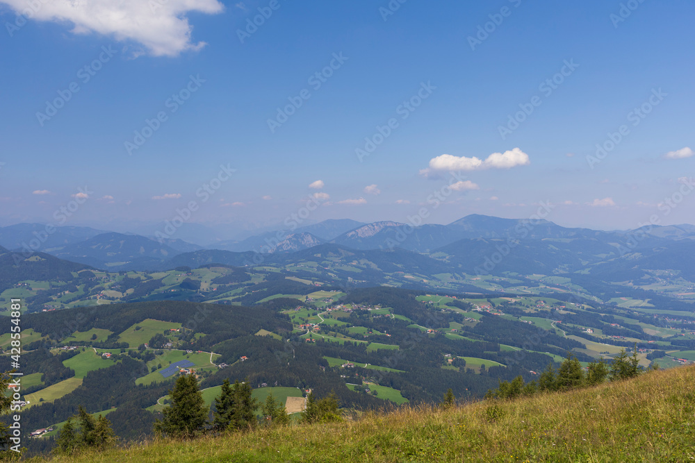 Naklejka premium Sunny day in Alpine mountain fields with panoramic view to valley, Austria