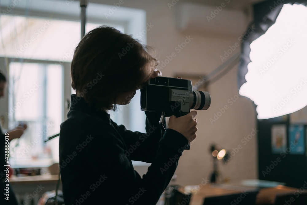 Female director of photography with a film camera on the shooting