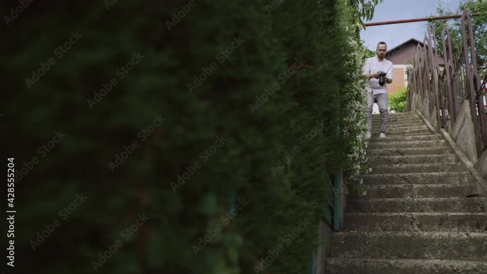 photographer with photo camera walks around the small European town. photographer with photo camera walks around the small European town.