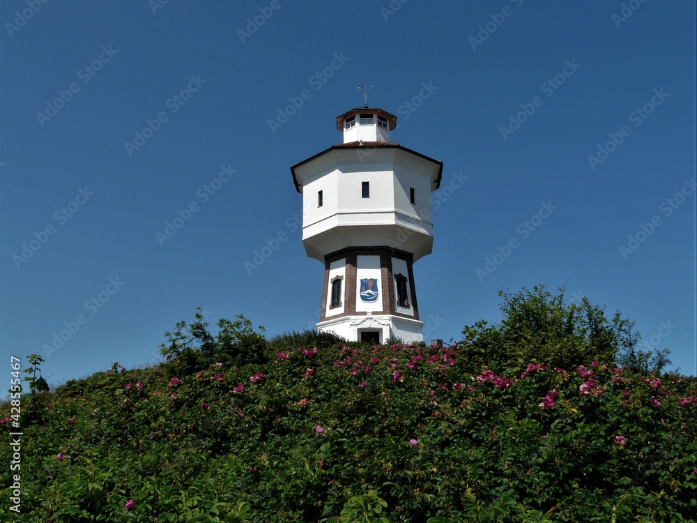Alter Wasserturm mit blühenden Rosensträuchern auf der Insel Langeoog / Ostfriesland