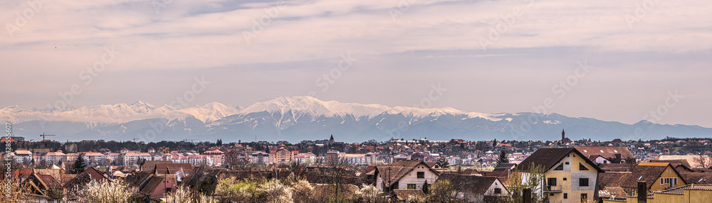 Panoramic view of the Sibiu city with snow covered Fagaras mountains in the back, part of the Carpathian mountains, Romania