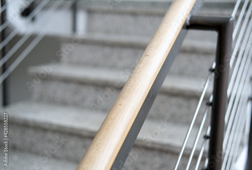 Nahaufnahme eines Handlaufs aus Holz und Stahl, Detail einer modernen Treppe in einem neuen Gebäude, selektiver Fokus 