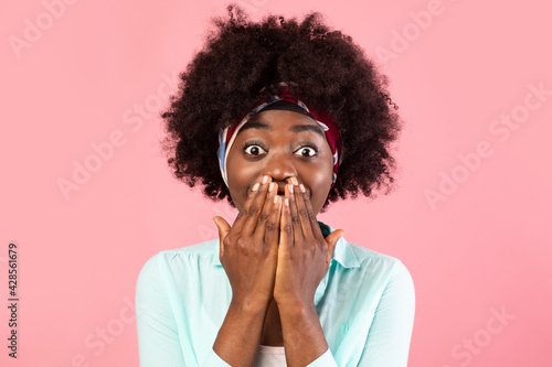 Excited Black Lady Covering Mouth Posing Over Pink Studio Background