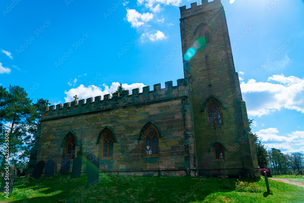 Fototapeta premium Ancient church against blue sky with lens flare