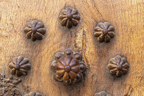 Close-up of an antique wooden door decorated with iron elements