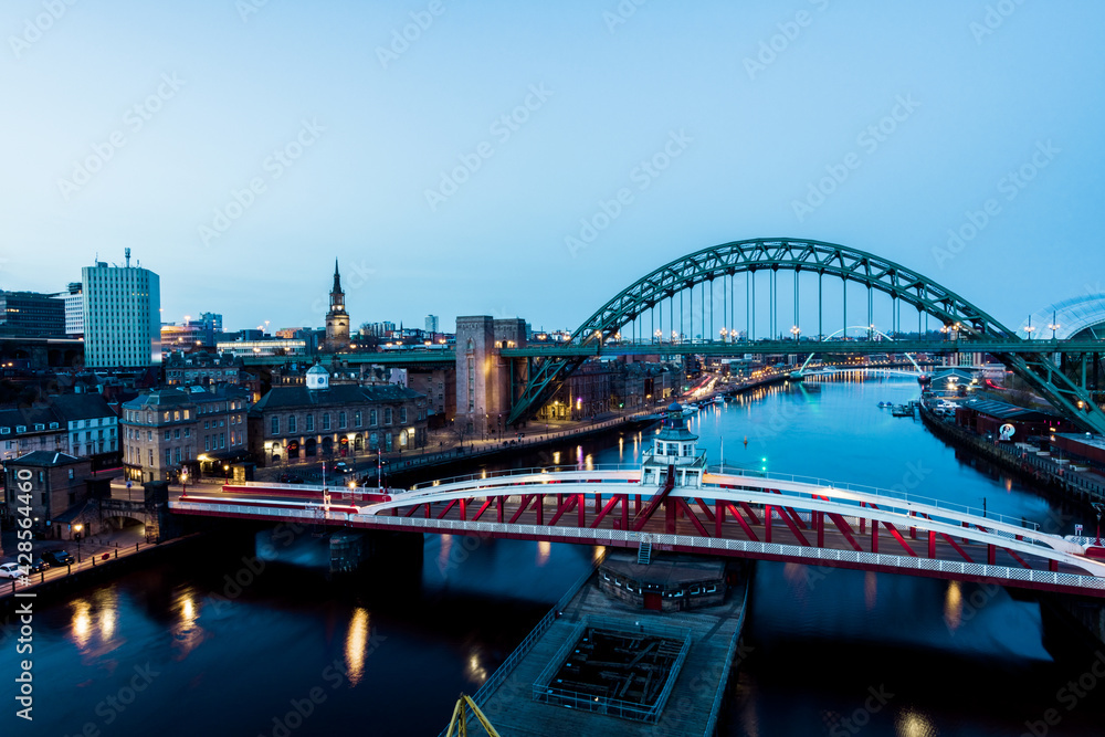 Fototapeta premium Newcastle upon Tyne UK: 30th March 2021: Newcastle Gateshead Quayside at night, with of Tyne Bridge and city skyline, long exposure during blue hour
