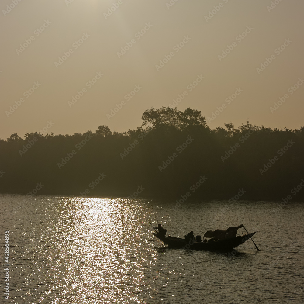 Beautiful after sunrise landscape view with fishing boat silhouette in the Sundarbans, a UNESCO World Heritage site, Bangladesh