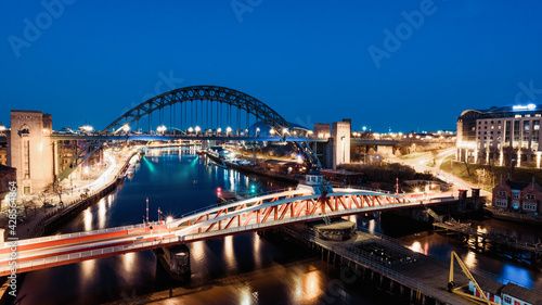 Newcastle upon Tyne UK: 30th March 2021: Newcastle Gateshead Quayside at night, with of Tyne Bridge and city skyline, long exposure during blue hour