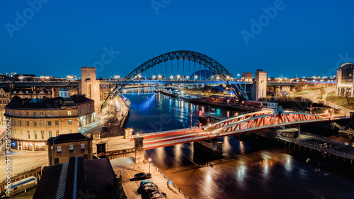 Newcastle upon Tyne UK: 30th March 2021: Newcastle Gateshead Quayside at night, with of Tyne Bridge and city skyline, long exposure during blue hour photo