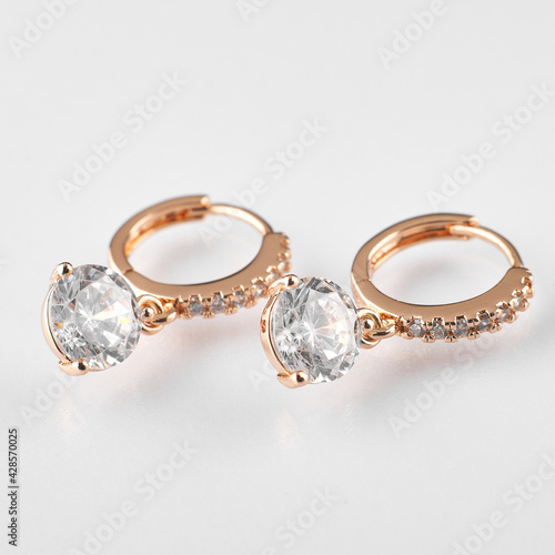 earrings of gold color with a large stone on a white background