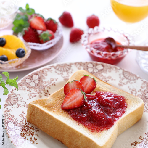 Delicious toast with strawberry jam, fresh strawberry and butter.
Selective focus. いちごジャムトースト