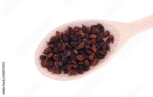 Dried sea buckthorn berries in wooden spoon isolated on white